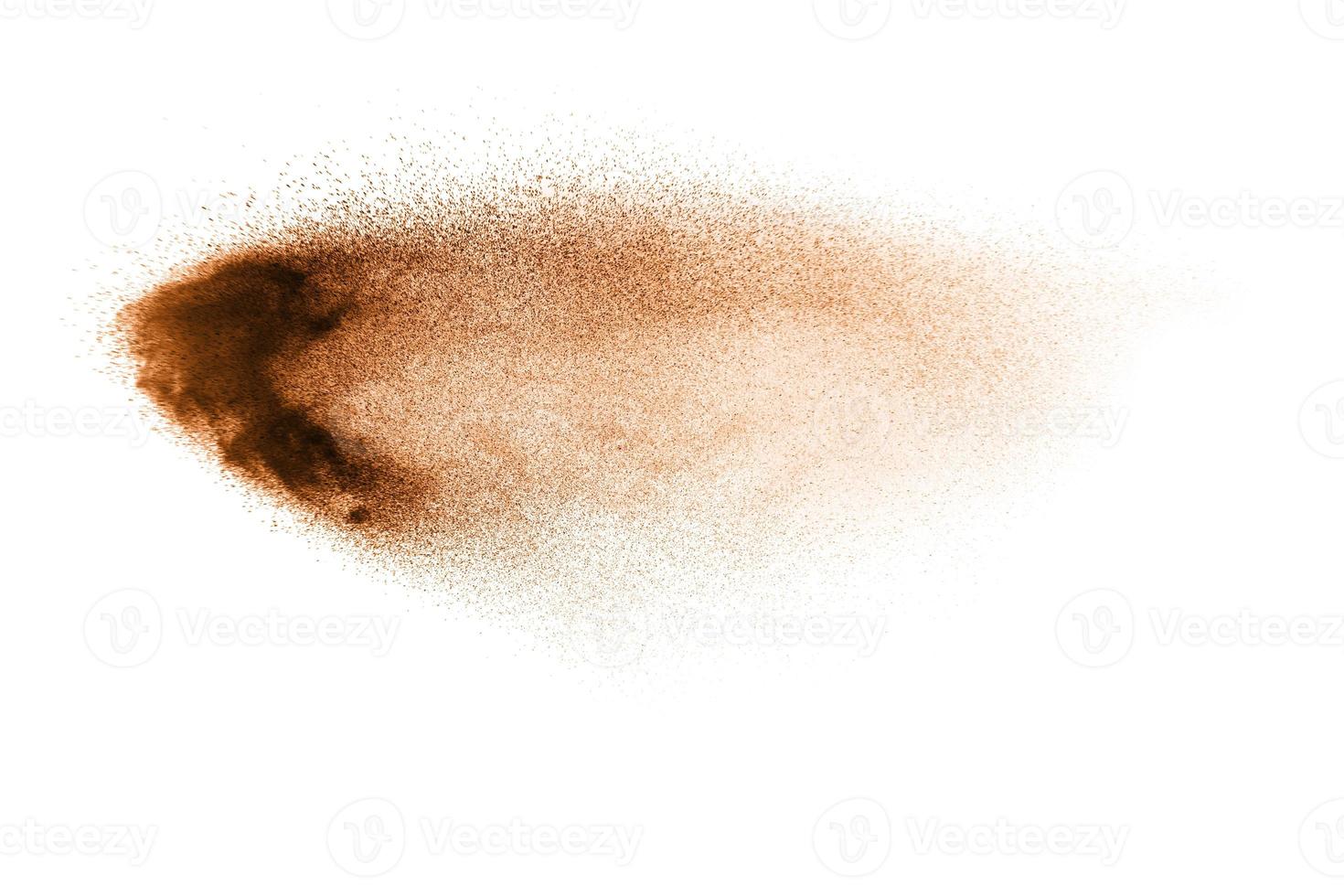 Abstract  brown color sand splash on white background. Brown dust particles explosion on background, throwing freeze stop motion concept. photo