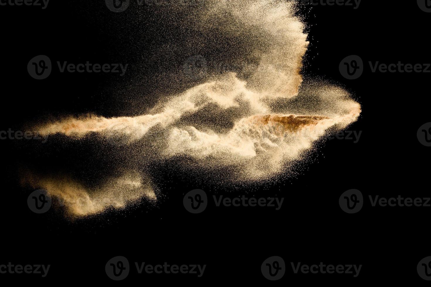 nube de arena abstracta.salpicadura de arena de color dorado sobre fondo oscuro.ola de mosca de arena amarilla en el aire. explosión de arena sobre fondo negro, lanzando el concepto de movimiento de parada de congelación. foto