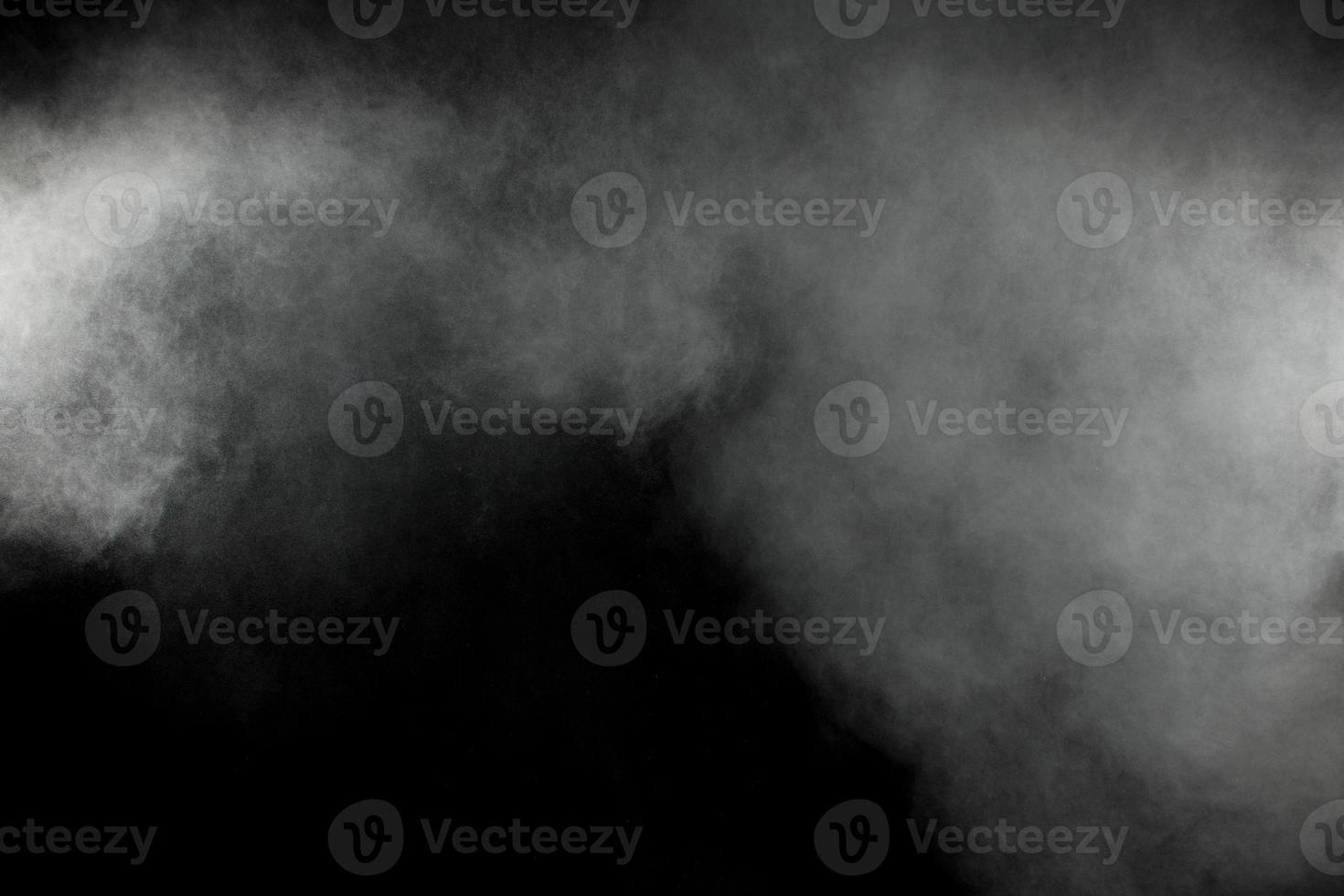 Abstract white powder explosion on a black background.Freeze motion of  white powder splash. photo
