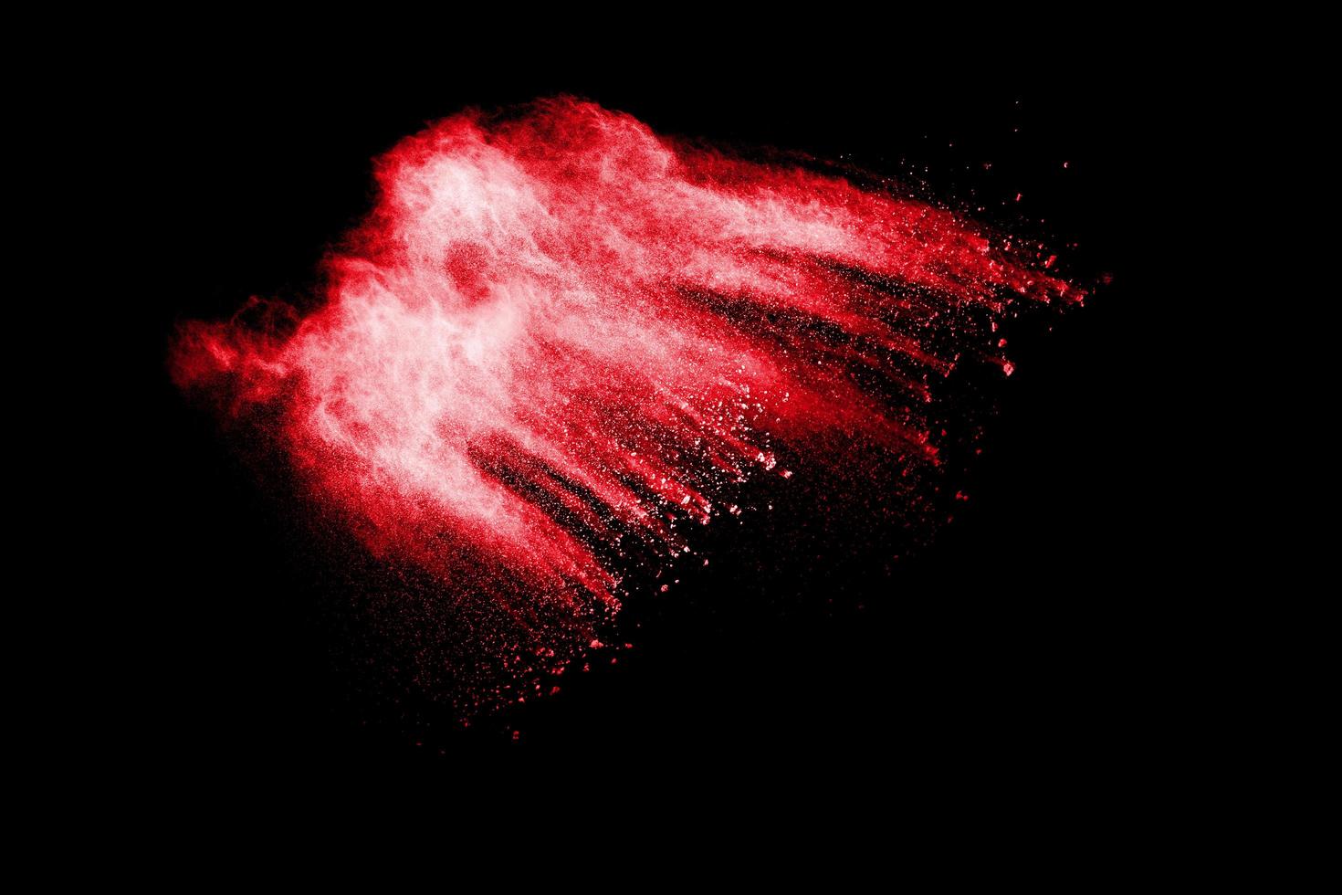 Abstract red dust splattered on white background. Red powder explosion.Freeze motion of red particles splashing. photo