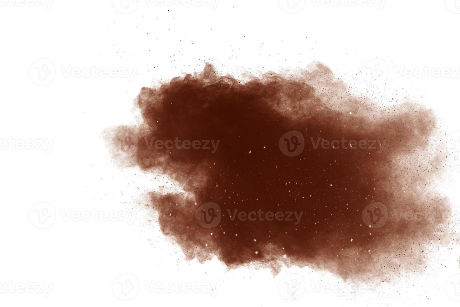 Freeze motion of brown powder exploding. Abstract design of color powder cloud against white background. photo