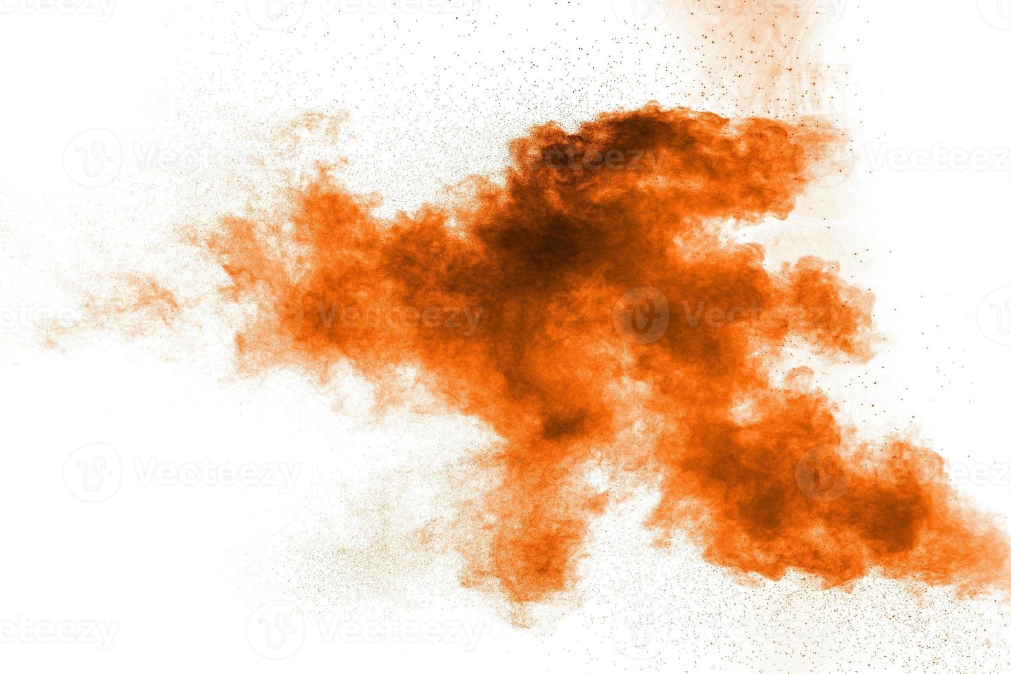 Abstract orange dust explosion on white background. Abstract orange powder splattered on white background. photo