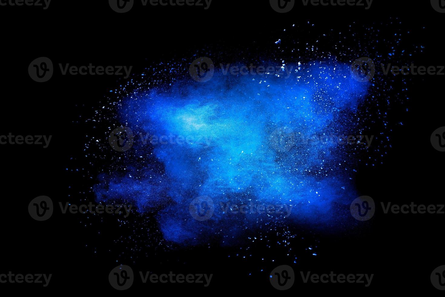 Blue color dust particle explosion cloud on black background.Color powder splash. photo