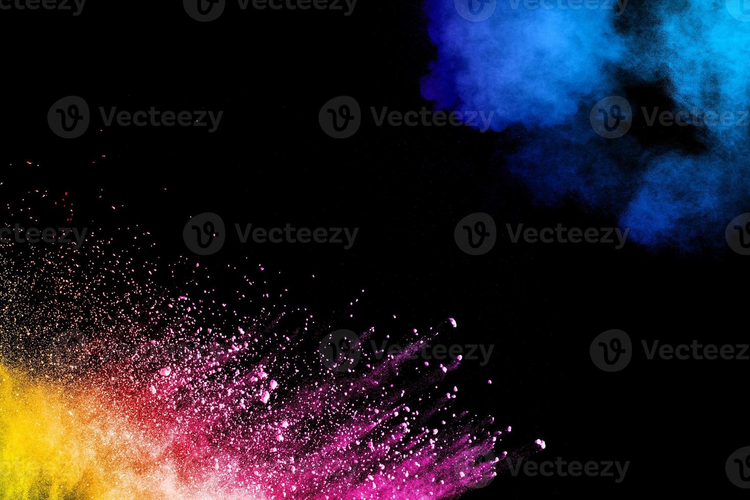 Abstract colorful powder explosion on black background.Freeze motion of dust splash.Painted Holi. photo