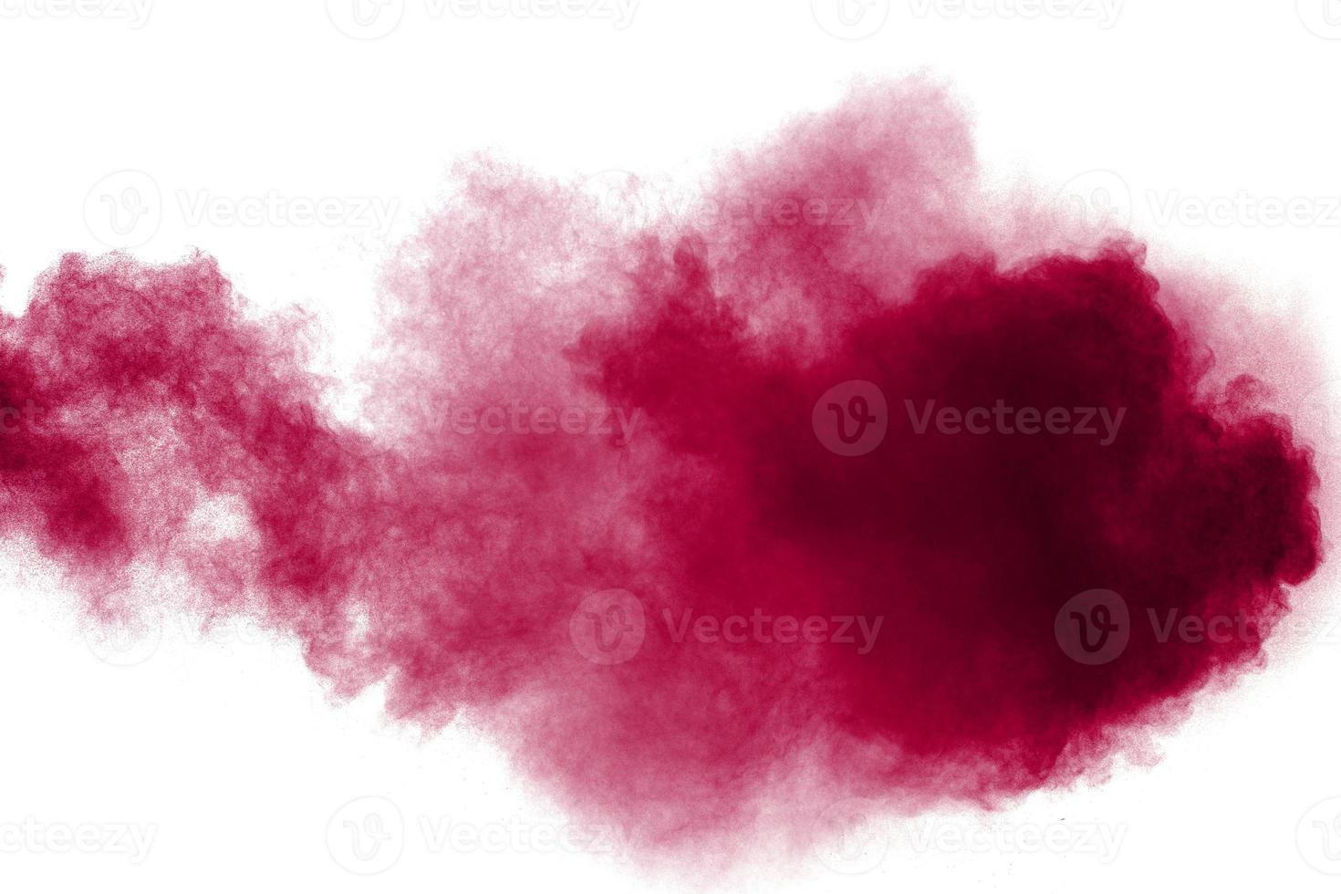 Abstract red dust splattered on white background. Red powder explosion.Freeze motion of red particles splashing. photo