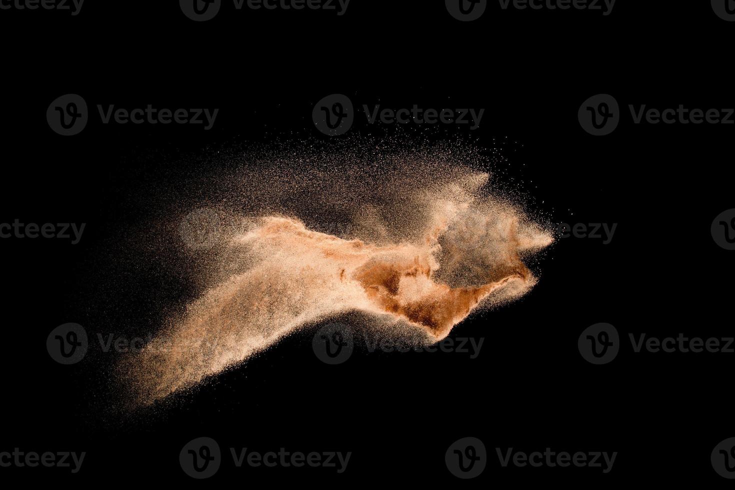 Dry river sand explosion isolated on black background. Abstract sand cloud.Brown colored sand splash against dark background. photo