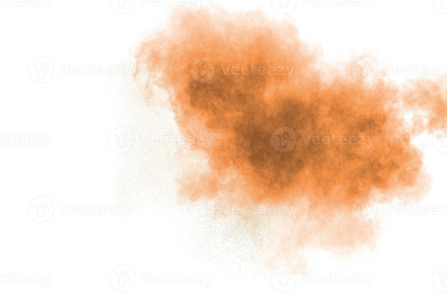 Freeze motion of brown powder exploding. Abstract design of color powder cloud against white background. photo