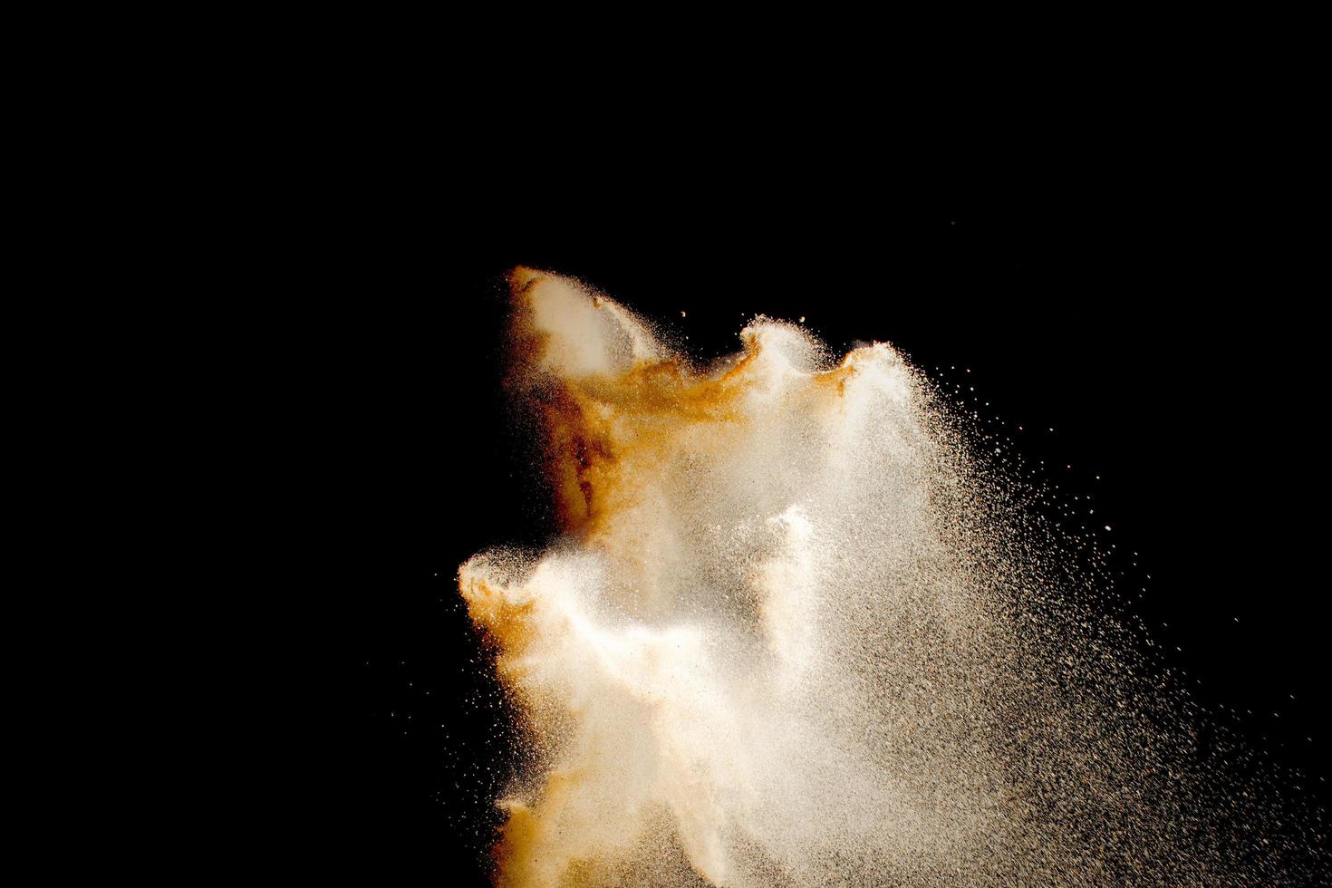 Brown color sand splash against black background. photo