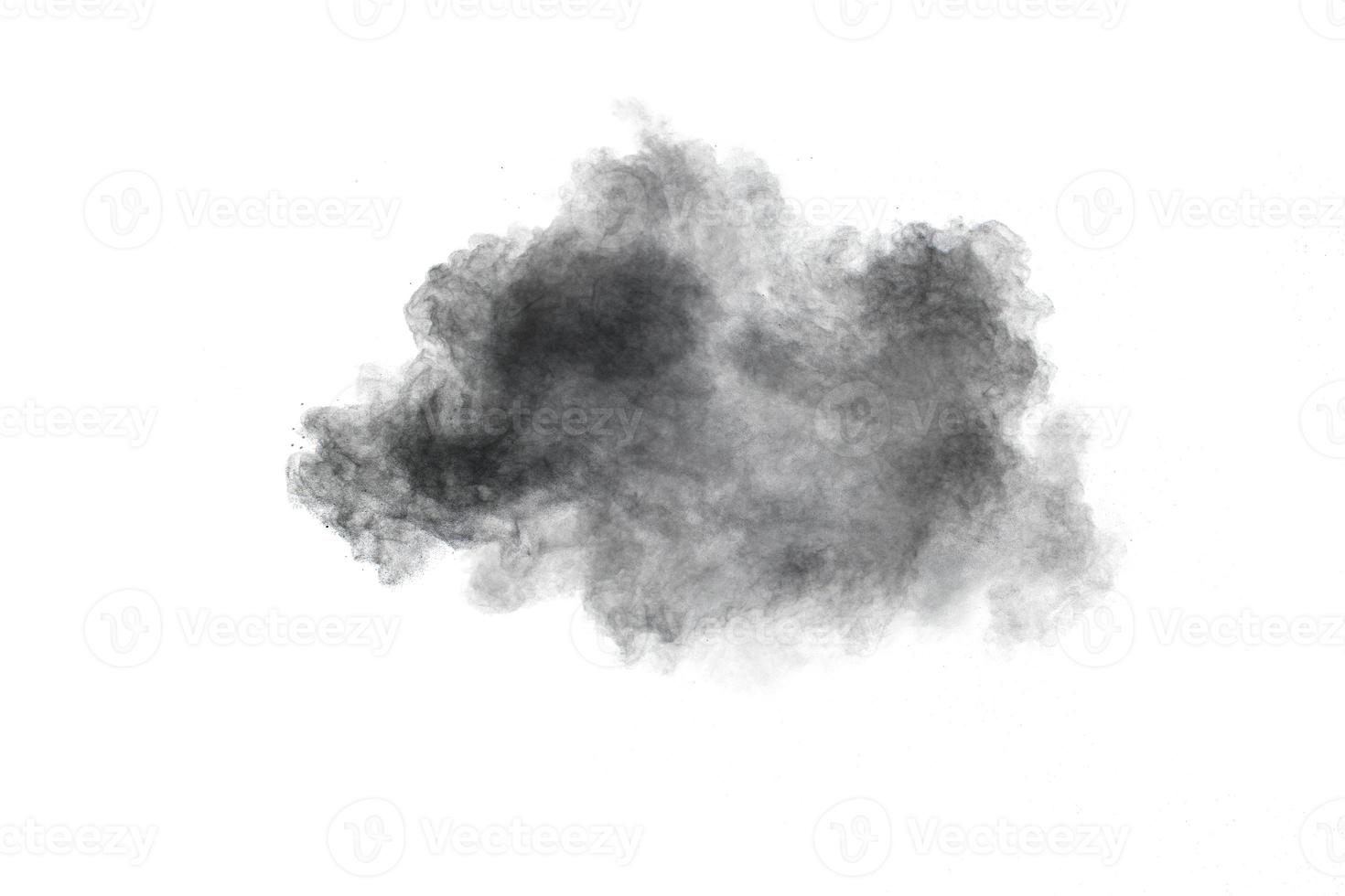 Explosión de polvo negro. Las partículas de carbón salpican sobre fondo blanco. foto