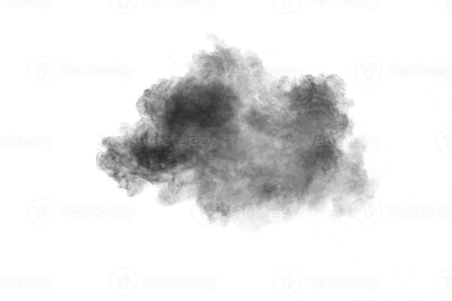 Black powder exploding.The particles of charcoal splash on white background. photo