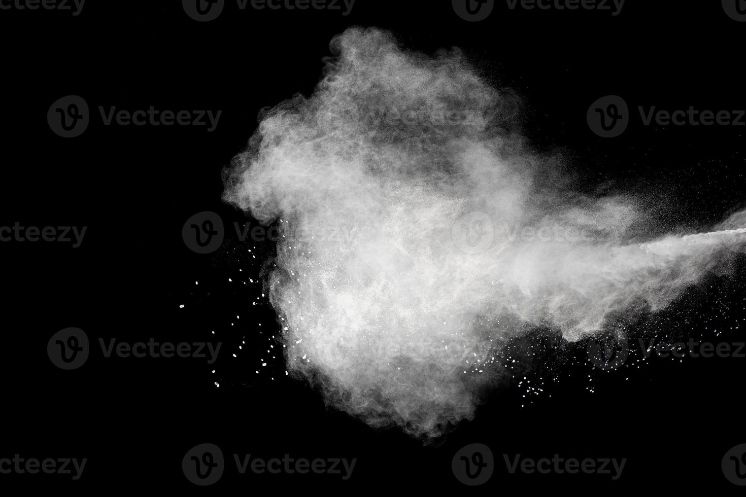 White powder explosion isolated on black background.White dust particles splash. photo