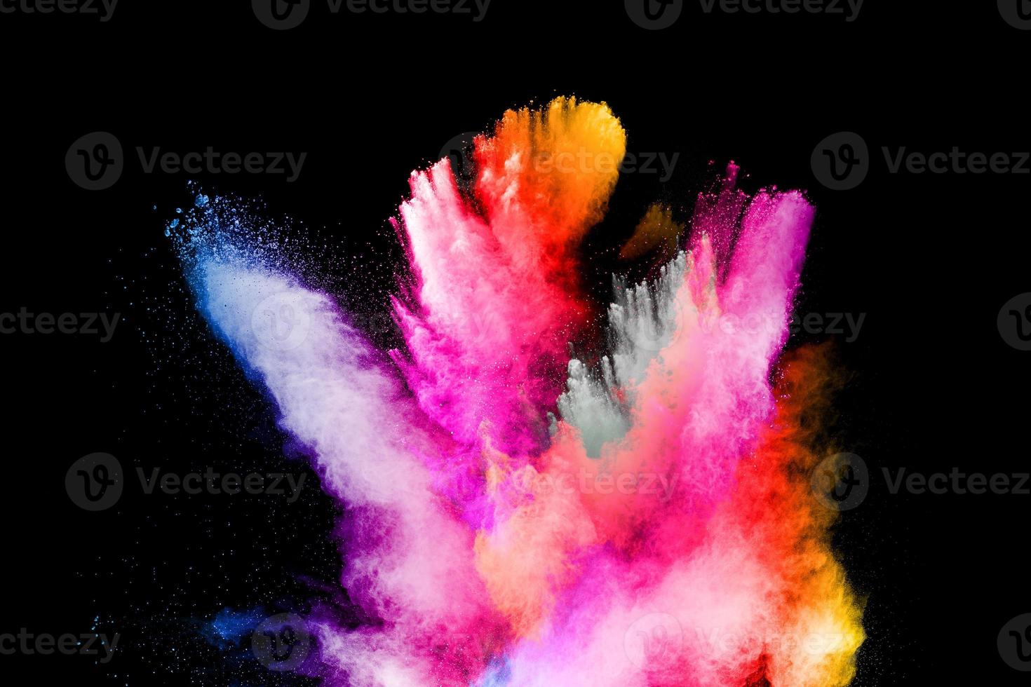 Multicolored powder explosion on black background.Color dust splash cloud on dark background.Launched colorful particles. photo