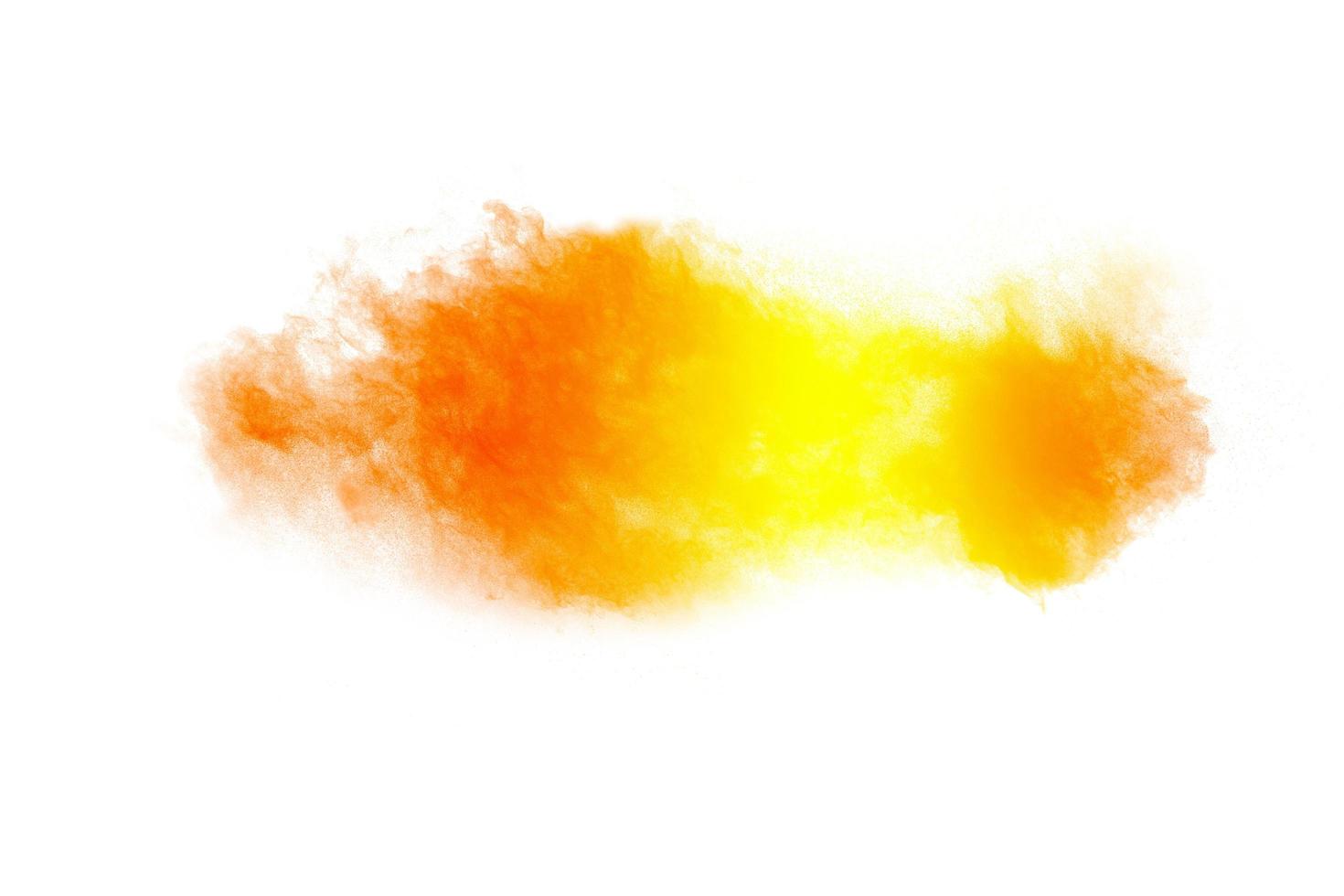 Abstract yellow orange powder explosion on white background. Freeze motion of yellow dust particles splash. photo