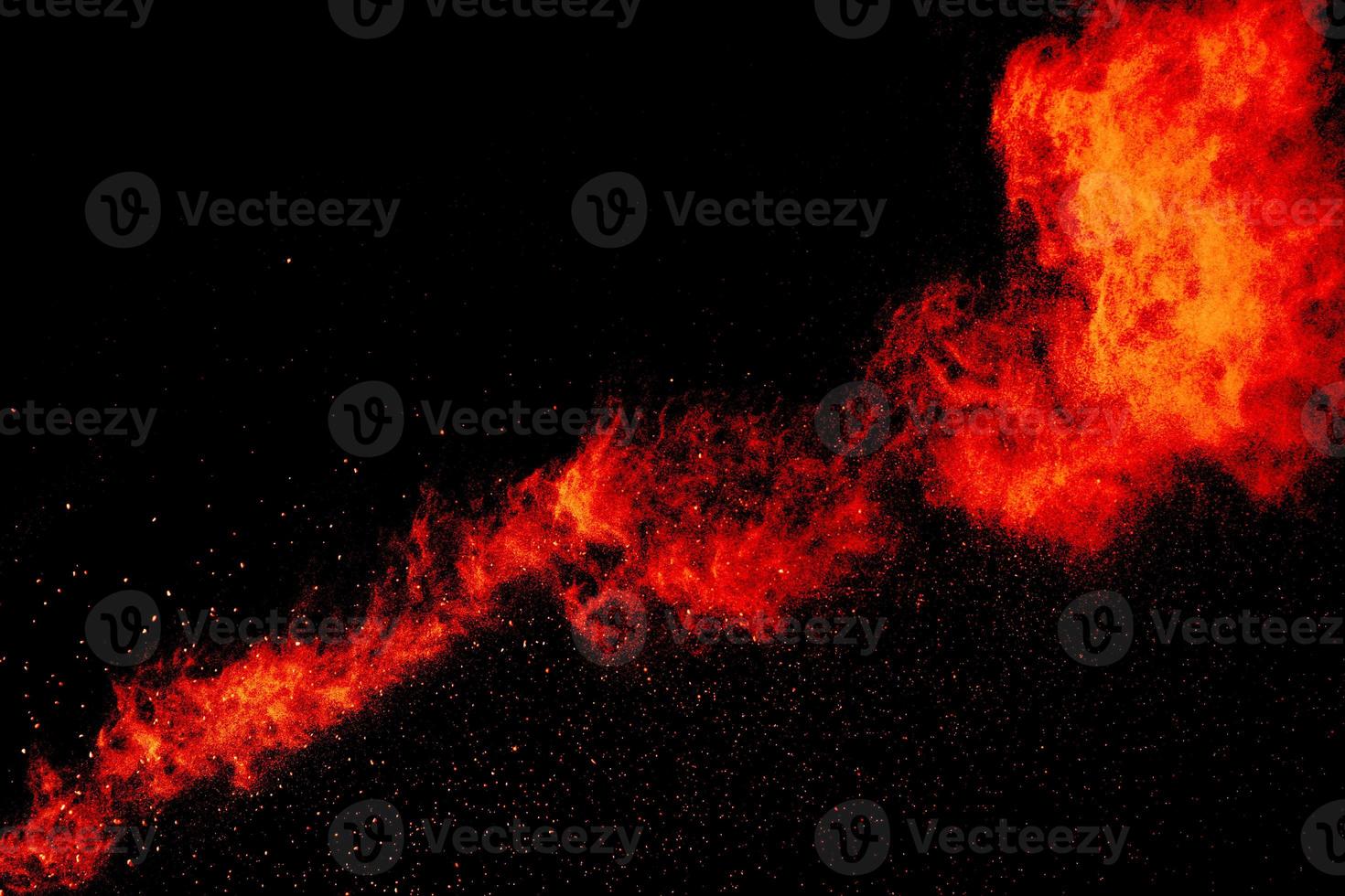 Red orange color powder explosion cloud isolated on black background. photo