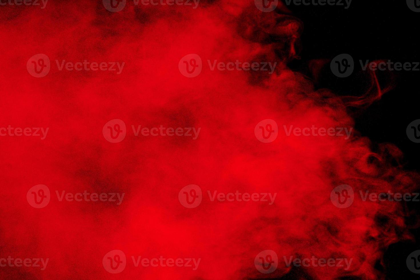 Red particles explosion on black background.Freeze motion of red dust splash. photo
