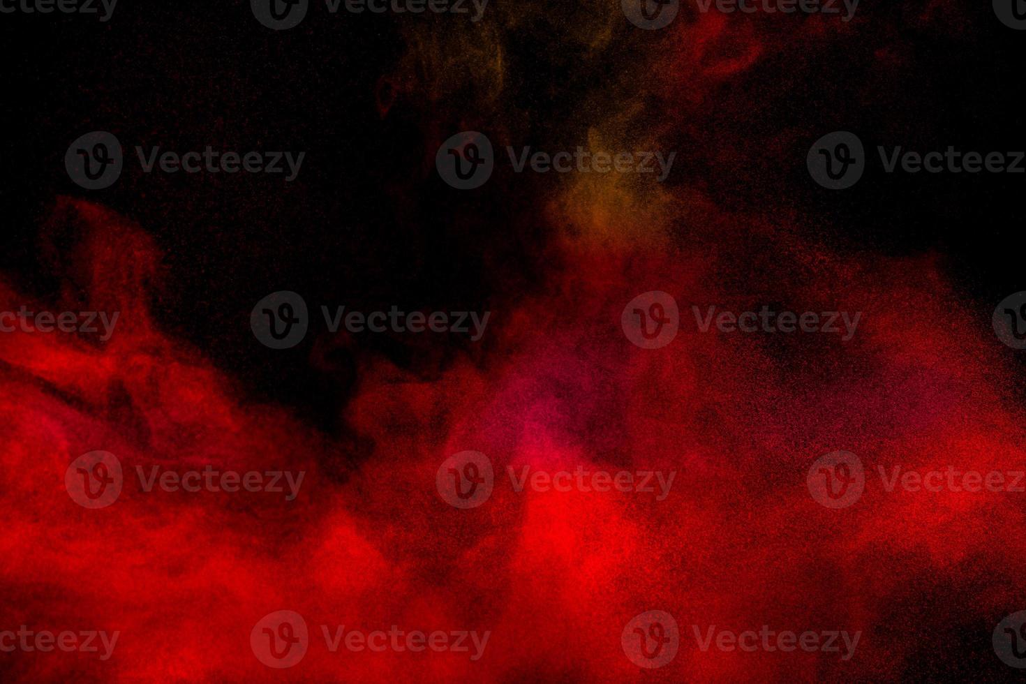 Red particles explosion on black background.Freeze motion of red dust splash. photo