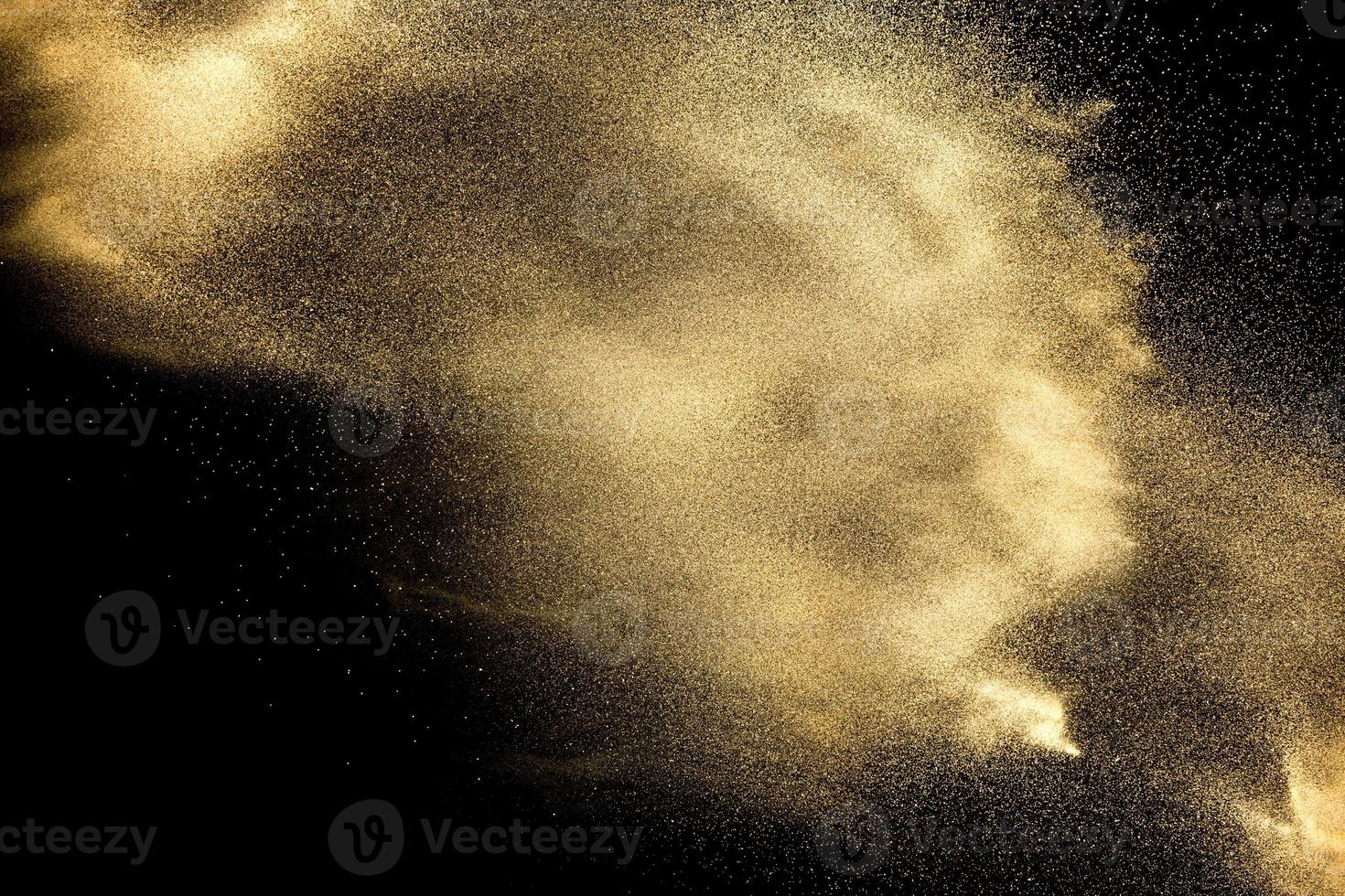 Sand explosion isolated on black background. Freeze motion of sandy dust splash. photo