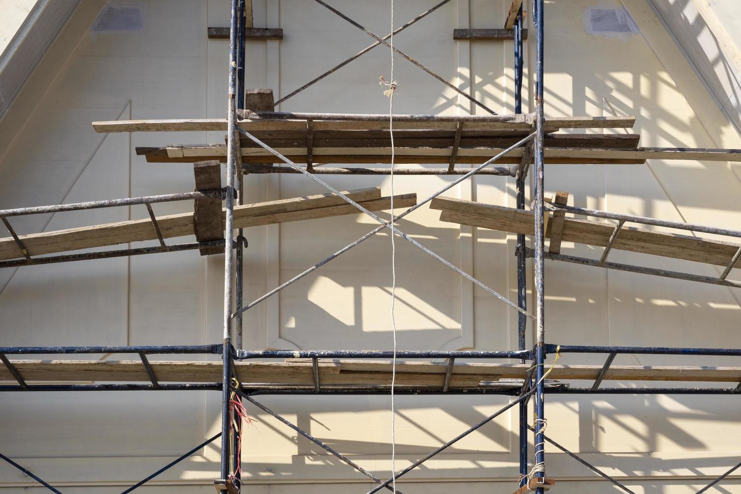 Sunlight and shadow on surface of metal scaffolding in front of roof truss structure under construction, renovation and improvement concept photo