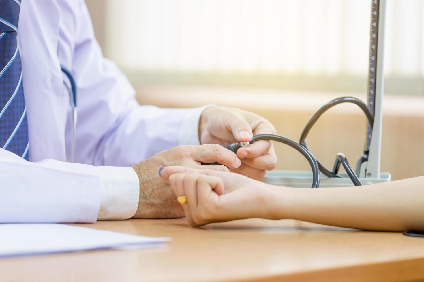 Doctor using sphygmomanometer checking blood pressure to a patient, doctor checking blood pressure photo