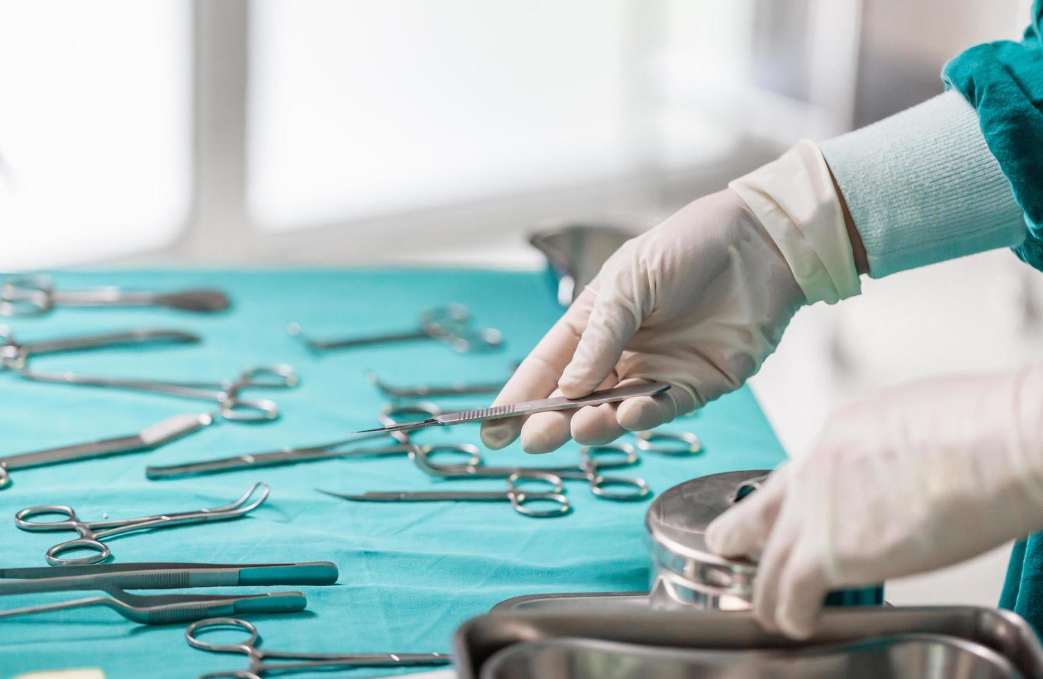 Doctor holds surgical instruments in hand, Surgeons hands with scalpel at operation in operating room photo