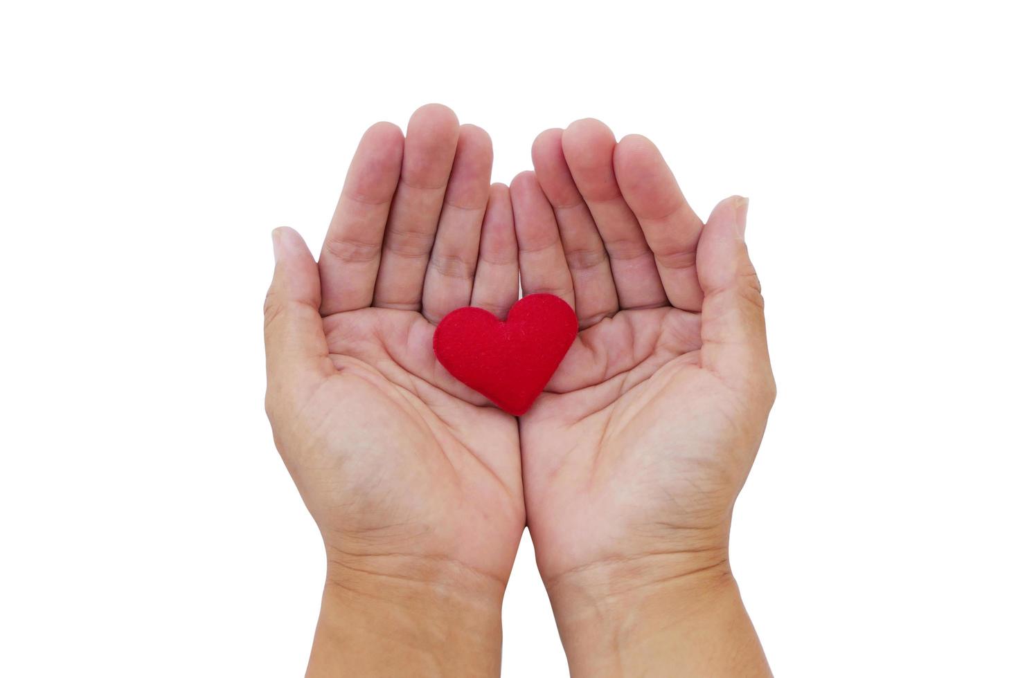 Red heart in kid hand isolated on white background. Love and giving concept. photo