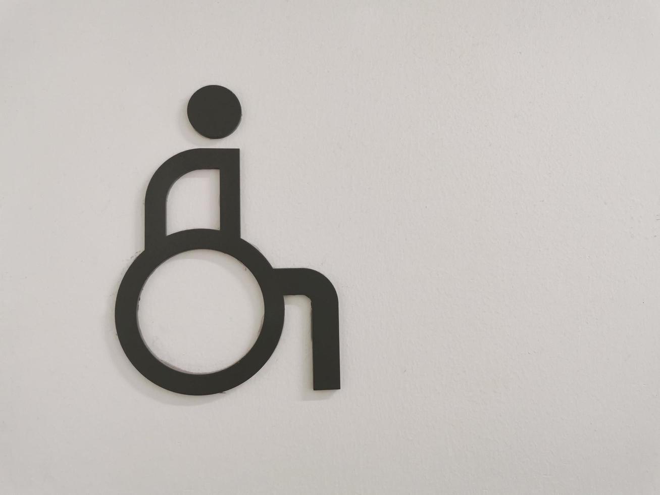 Disable person sign for restroom on wall. Handicapped accessible restroom. photo