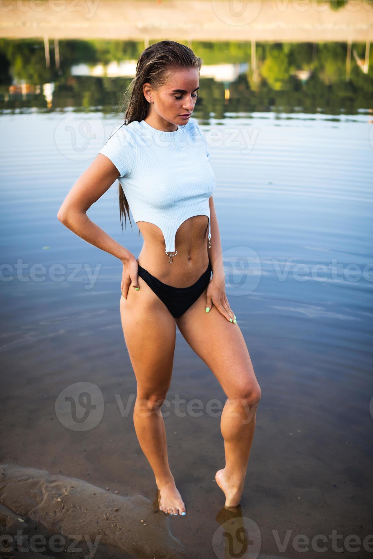 https://static.vecteezy.com/system/resources/previews/007/116/306/large_2x/a-beautiful-brunette-model-in-black-panties-and-a-t-shirt-posing-in-the-water-in-front-of-the-camera-photo.jpg
