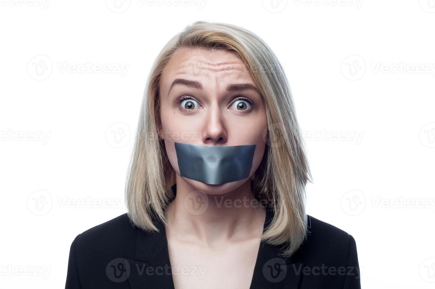 Girl with a mouth taped on a white background photo