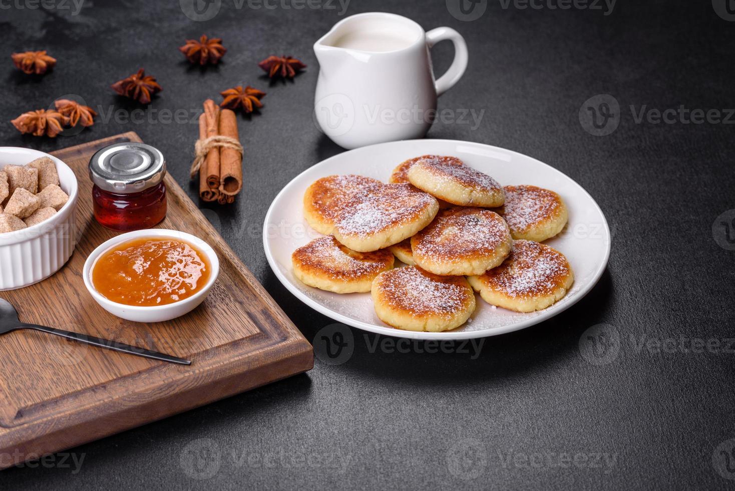 Cottage cheese pancakes with oats, syrniki on a black rustic background photo