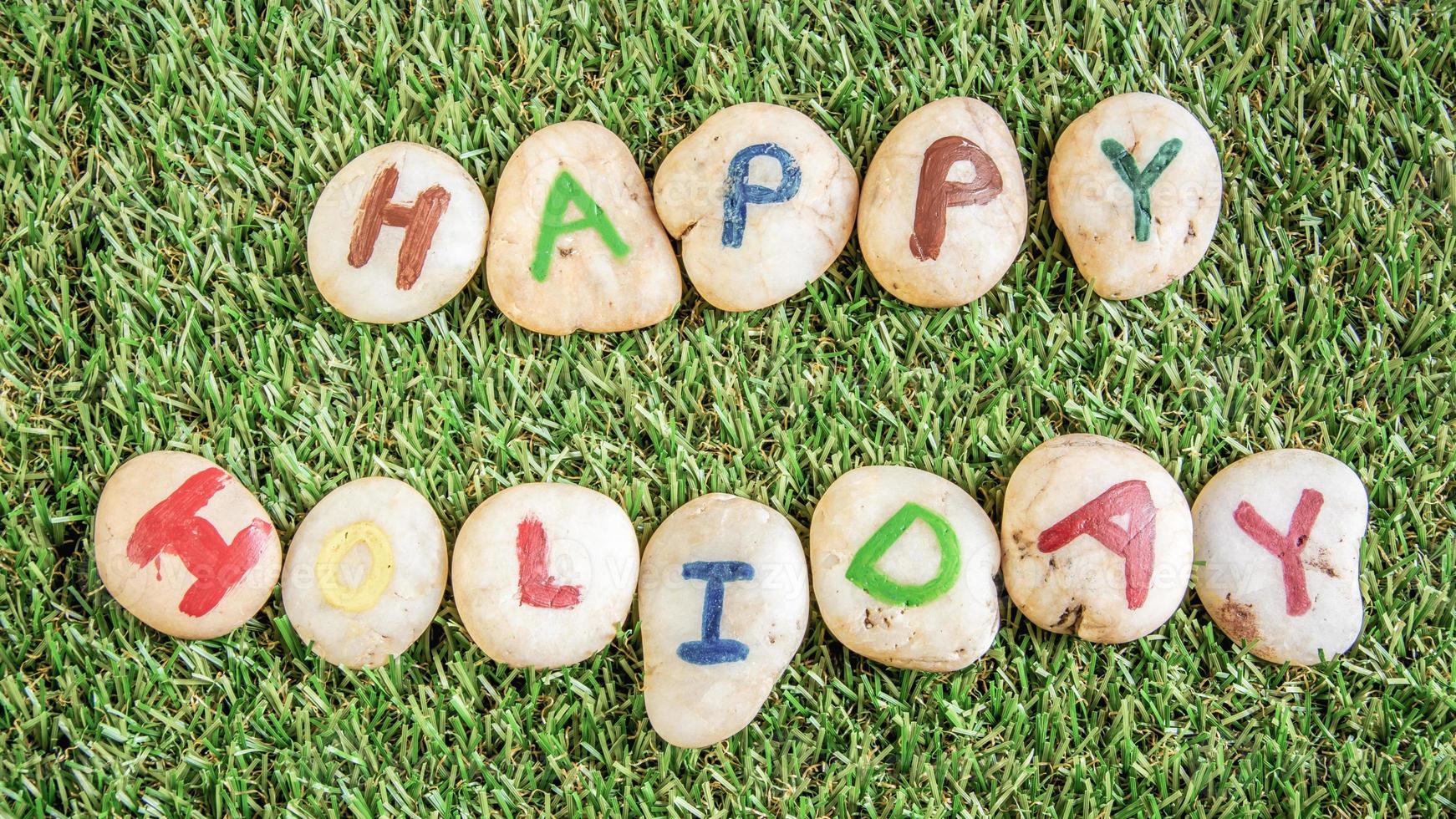 Happy holiday paint on stone , on the grass photo