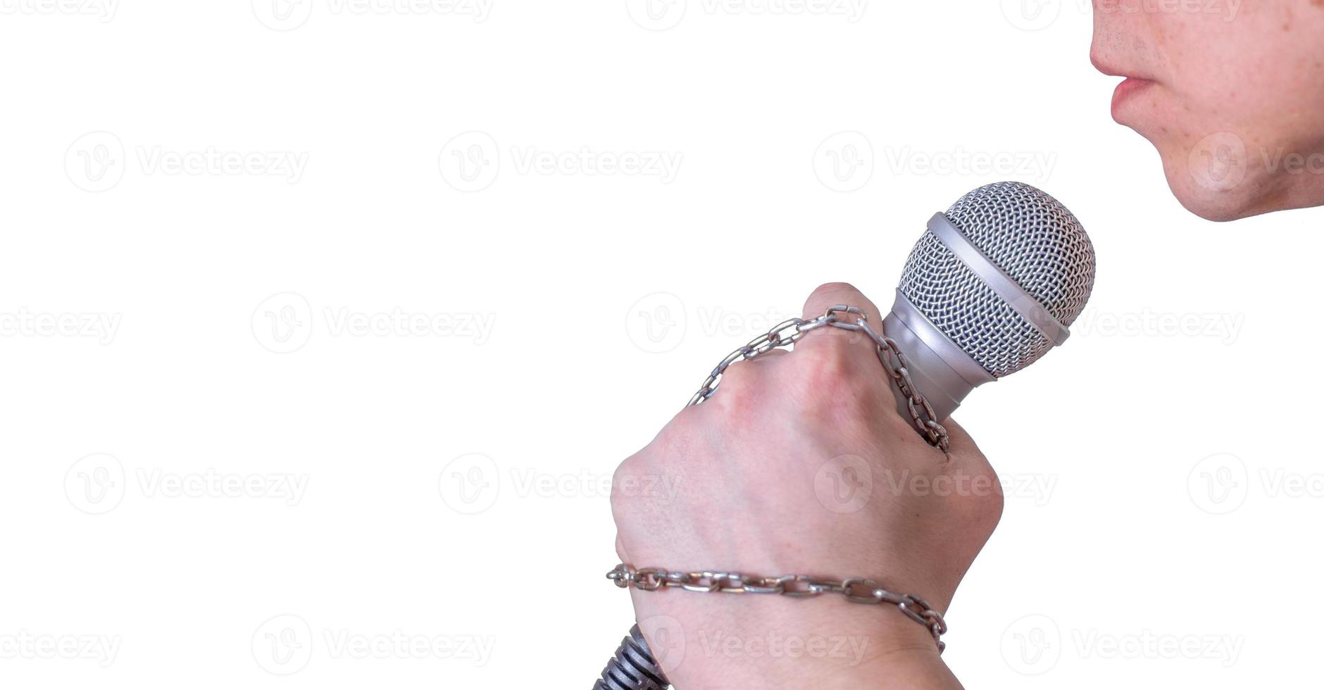 A man speaks into a microphone in close-up, against a white background. photo