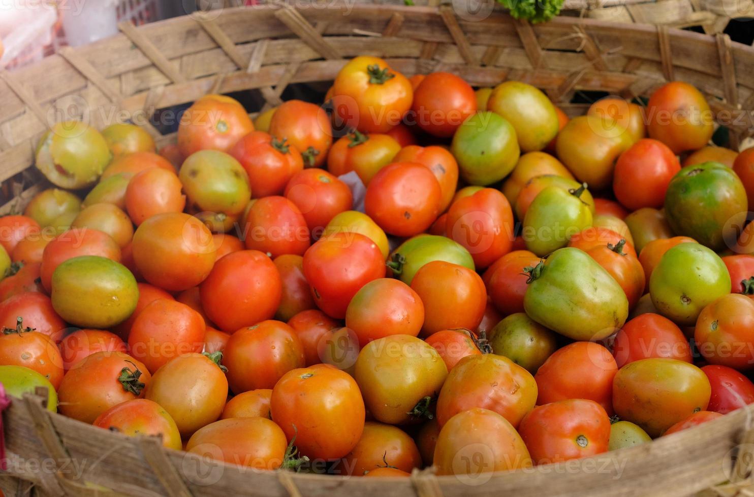 Fresh Tomato - Large quantities of tomato in the basket. Fresh tomatoes in the market photo