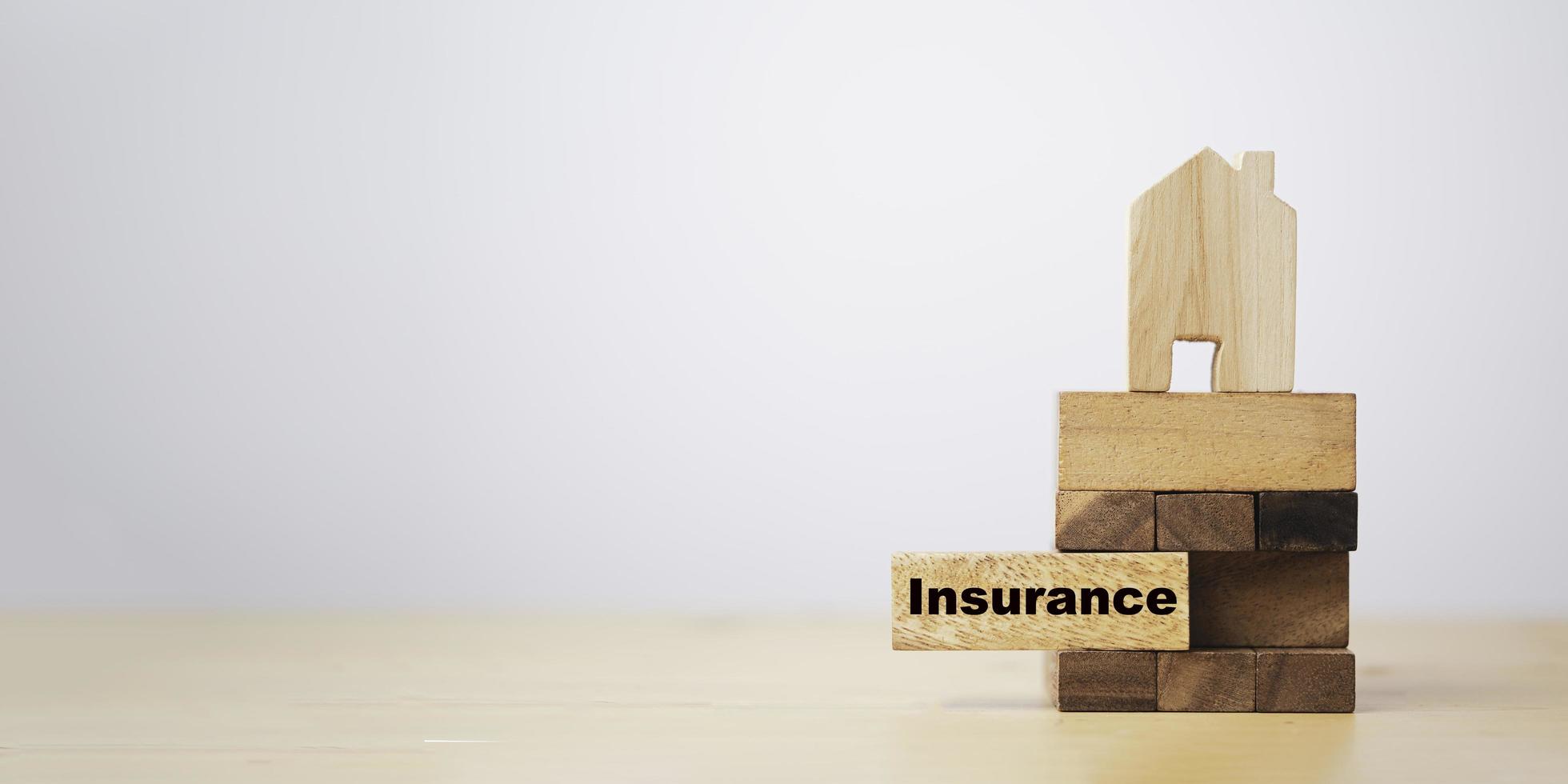 Pull out wooden block which print screen insurance wording with house on top for insurance asset protection concept. photo