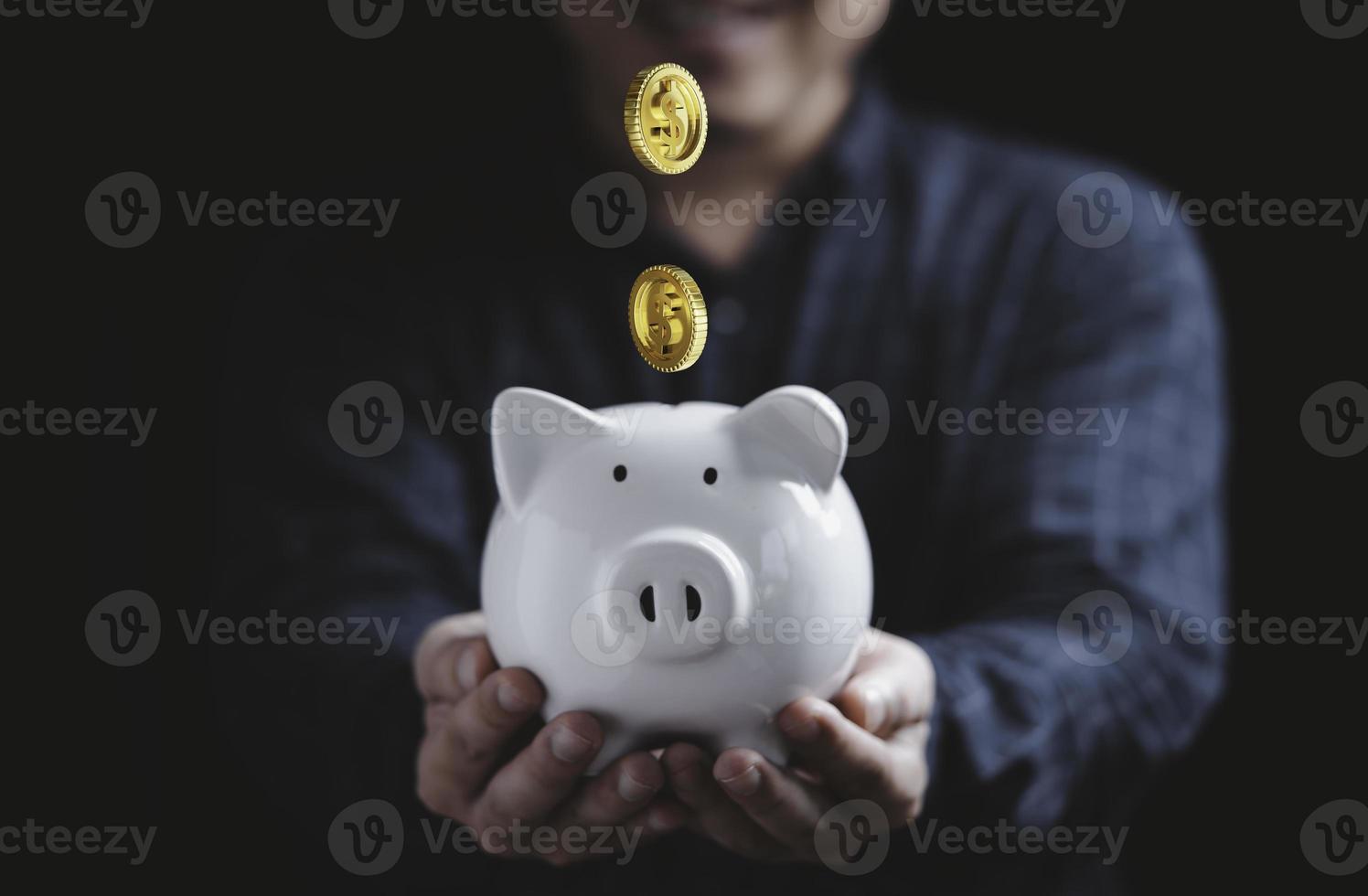 Businessman holding white piggy bank saving with golden coins falling for deposit and money saving investment concept. photo