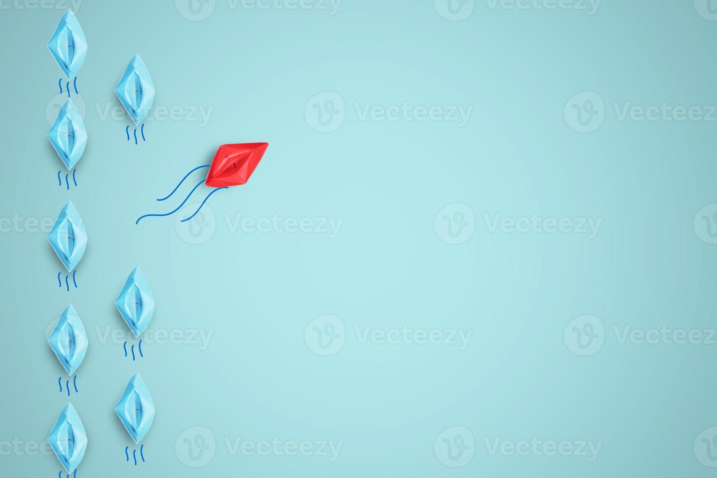 Red paper boat move out of line from blue ships in sea for leadership and different thinking idea concept. photo