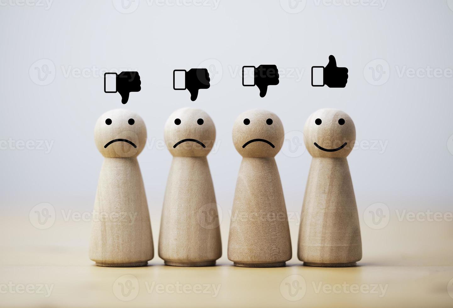 Smile face print screen on wooden figure among sadness figures for customer service evaluation and emotion mindset concept. photo