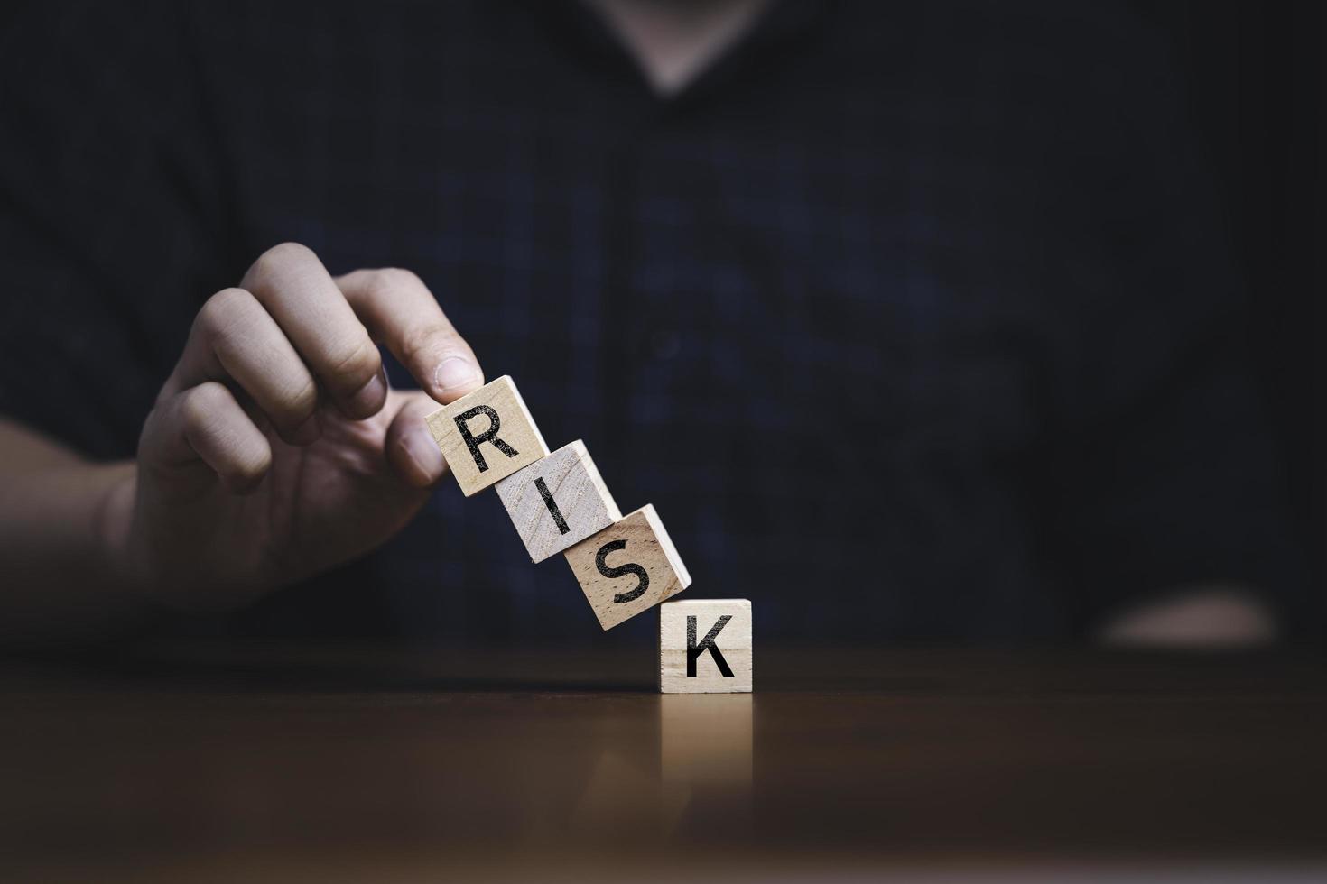 Hand touching to collapse block and printing risk wording for risk management concept. photo