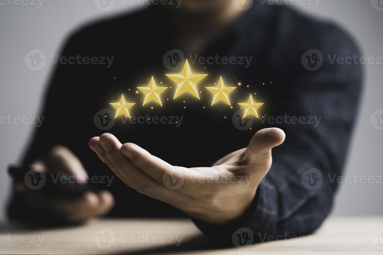 Businessman holding golden five stars for client customer feedback and evaluation after use service and product concept. photo