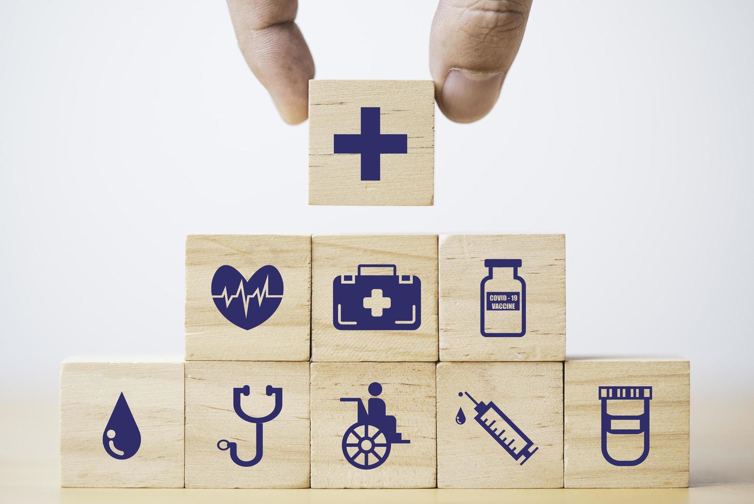 Hand putting and stacking Healthcare and medical icons which print screen on wooden cube block for health insurance concept. photo