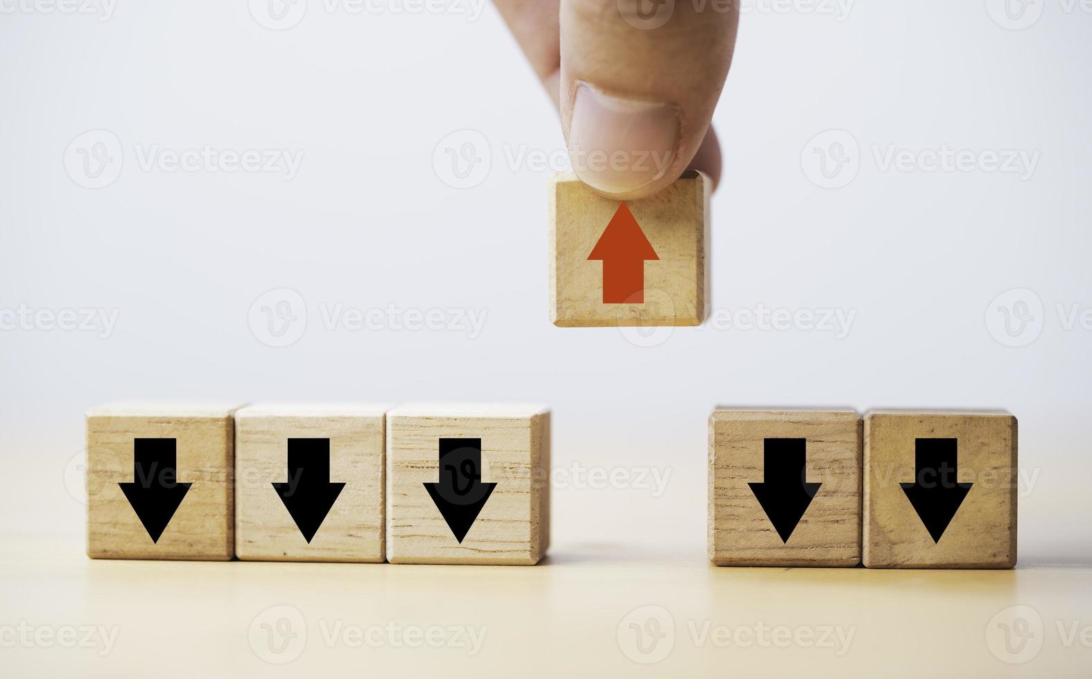 Hand holding increasing red arrow which move out and opposite way from black decreasing arrow for business and technology disruption concept. photo