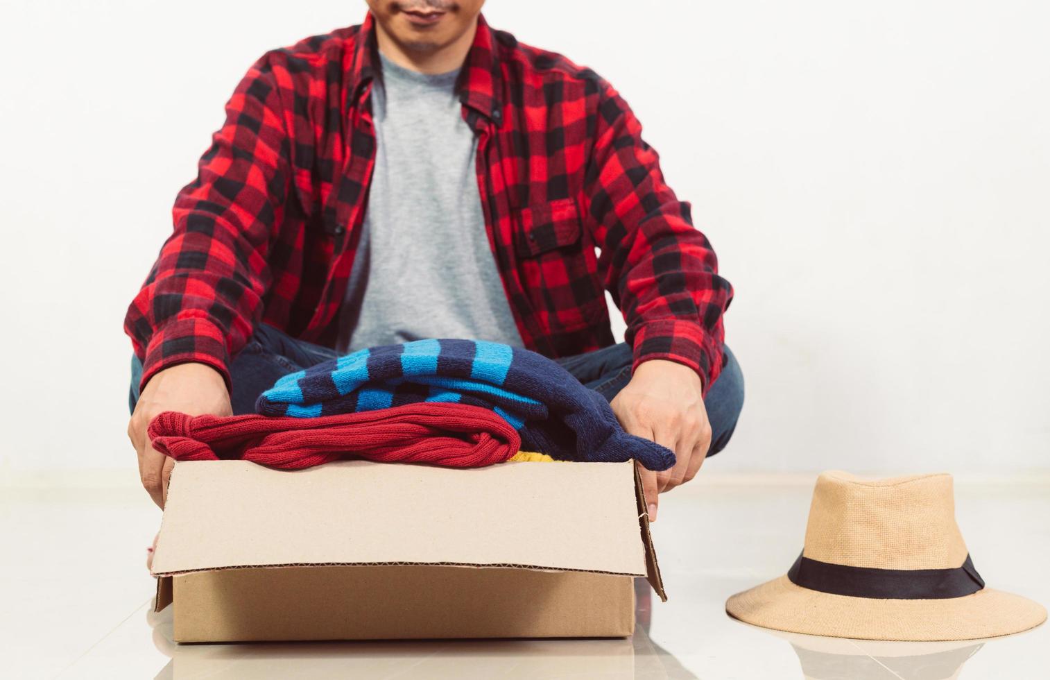 man holding a crate of second-hand clothes unused clothes photo