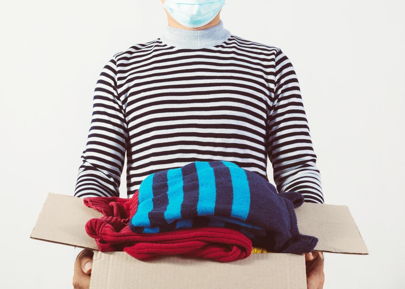 man holding a crate of second-hand clothes unused clothes photo