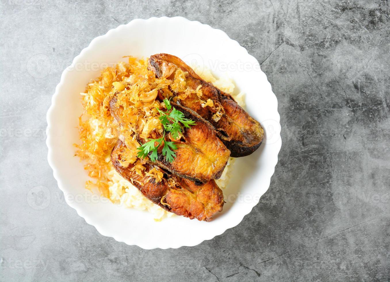 Deep fried sliced Pangasius fish with garlic, served with brown rice. photo