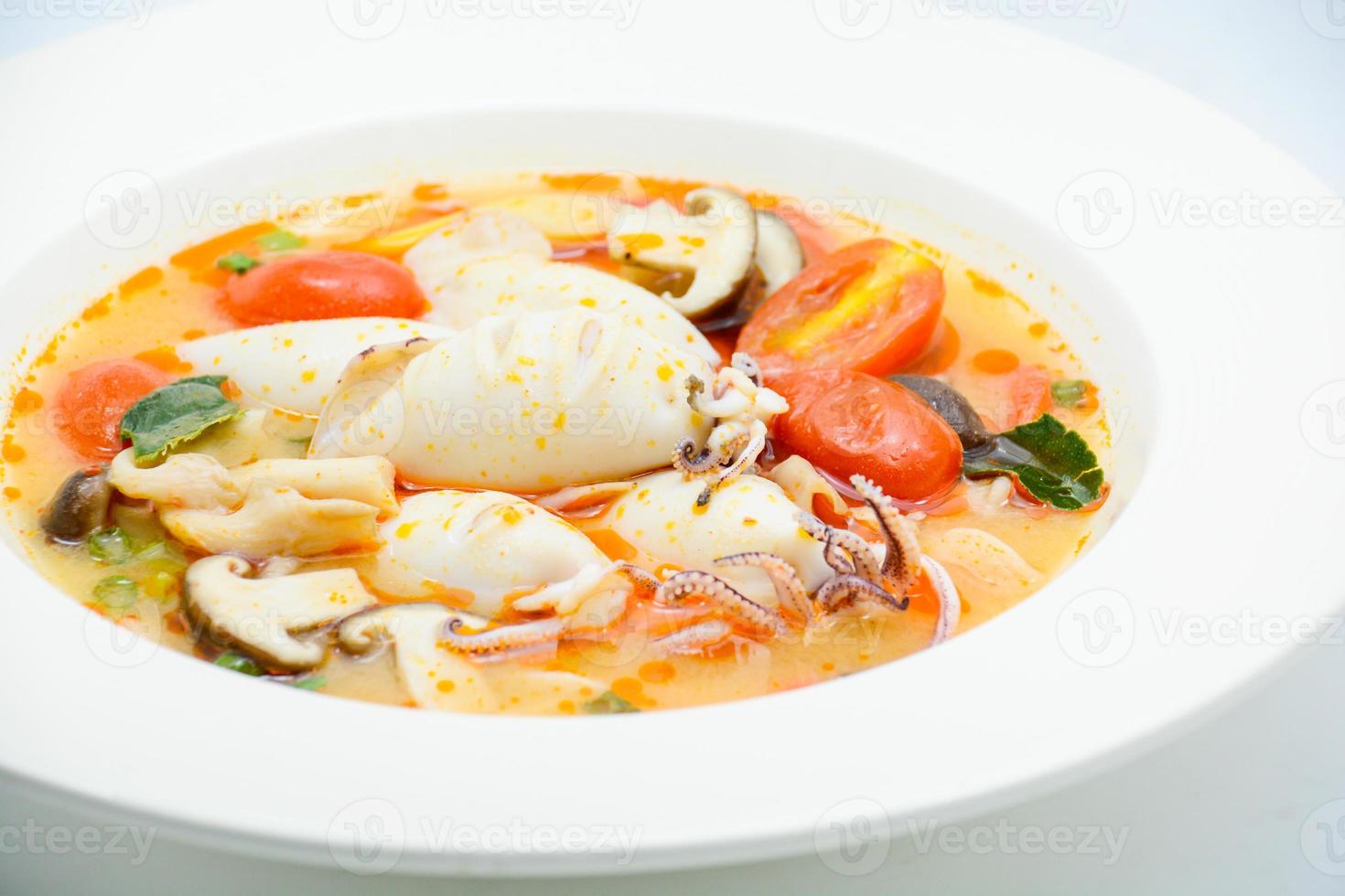Squids and lemon grass spicy soup with mushrooms, tomatoes and herbs photo