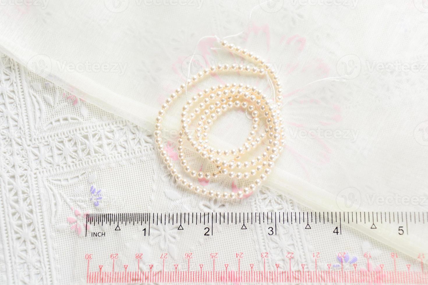 pearl necklace on white fabric background, Close up shot of glass pearls photo