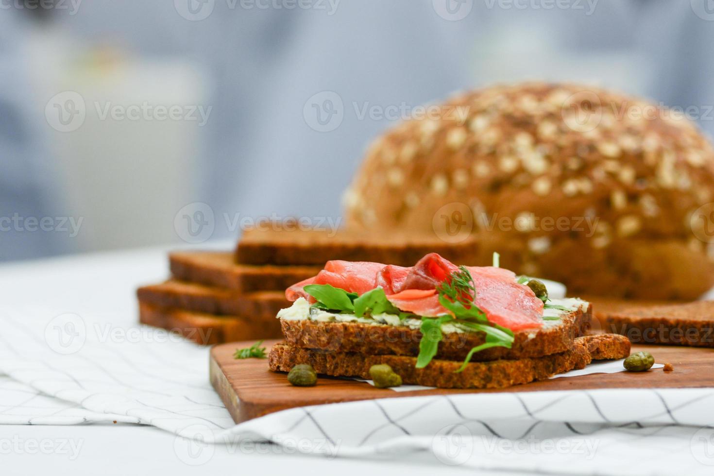Smoked salmon sandwich with cheese, pistachio and salad leaves, brown breads photo