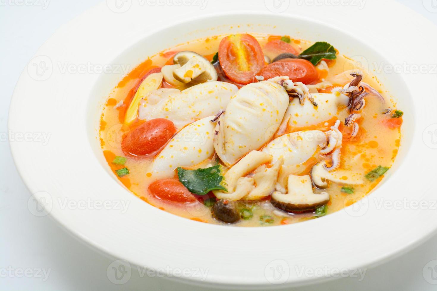 Squids and lemon grass spicy soup with mushrooms, tomatoes and herbs photo