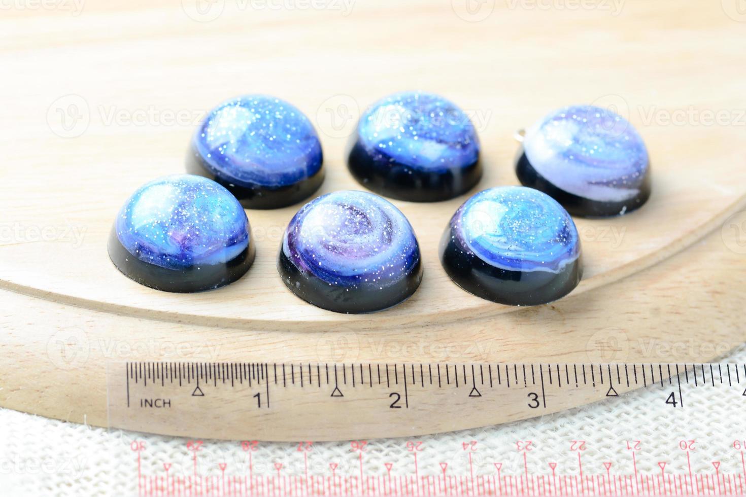 Create galaxy drink coasters using resin, glitter and pigment powders, handmade items. Suitable for keychains, necklace and pendant. photo