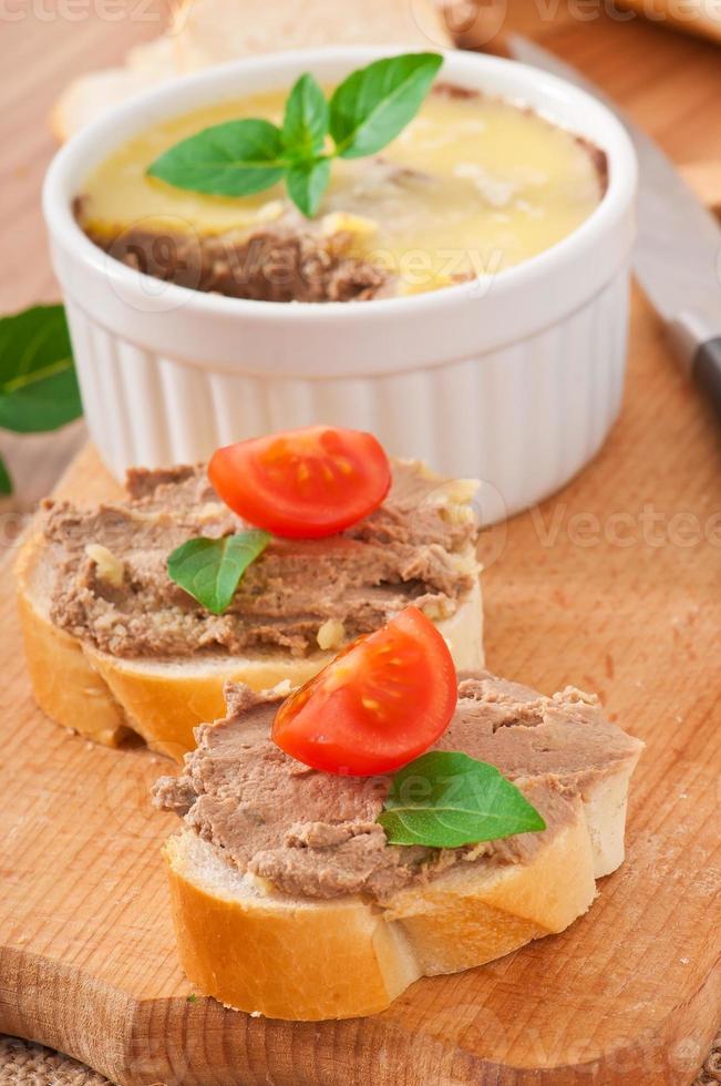 Homemade chicken liver pate, basil and slices of white bread photo
