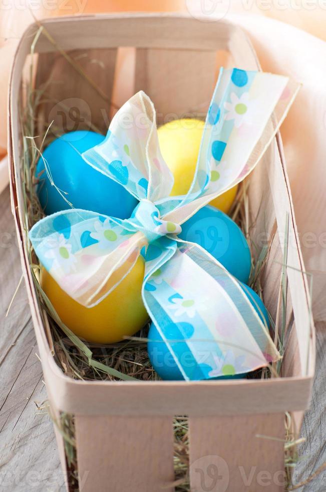 Easter eggs in nest on wooden background photo